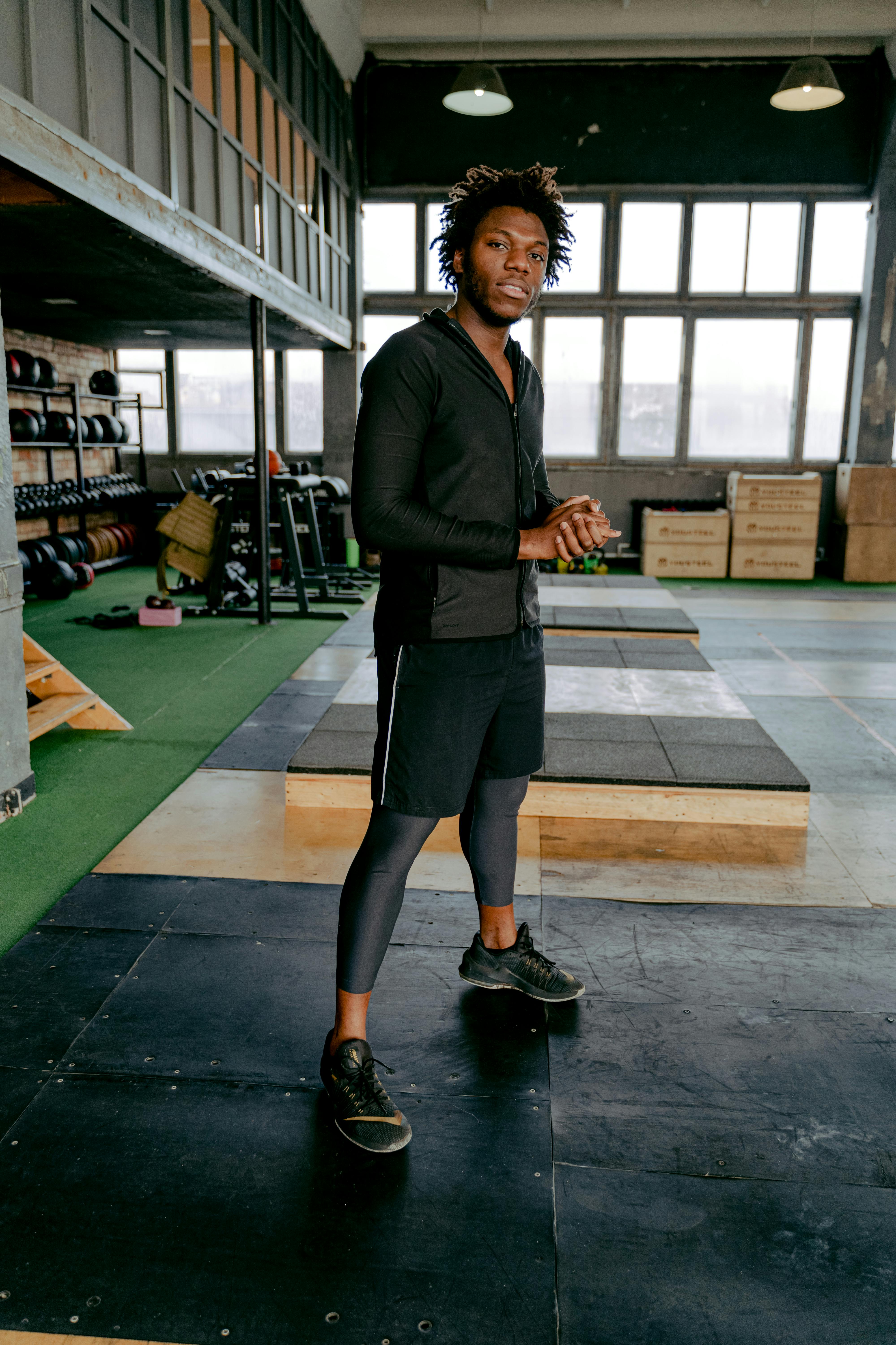 Portrait of an African American man in sports clothing standing indoors at a gym.