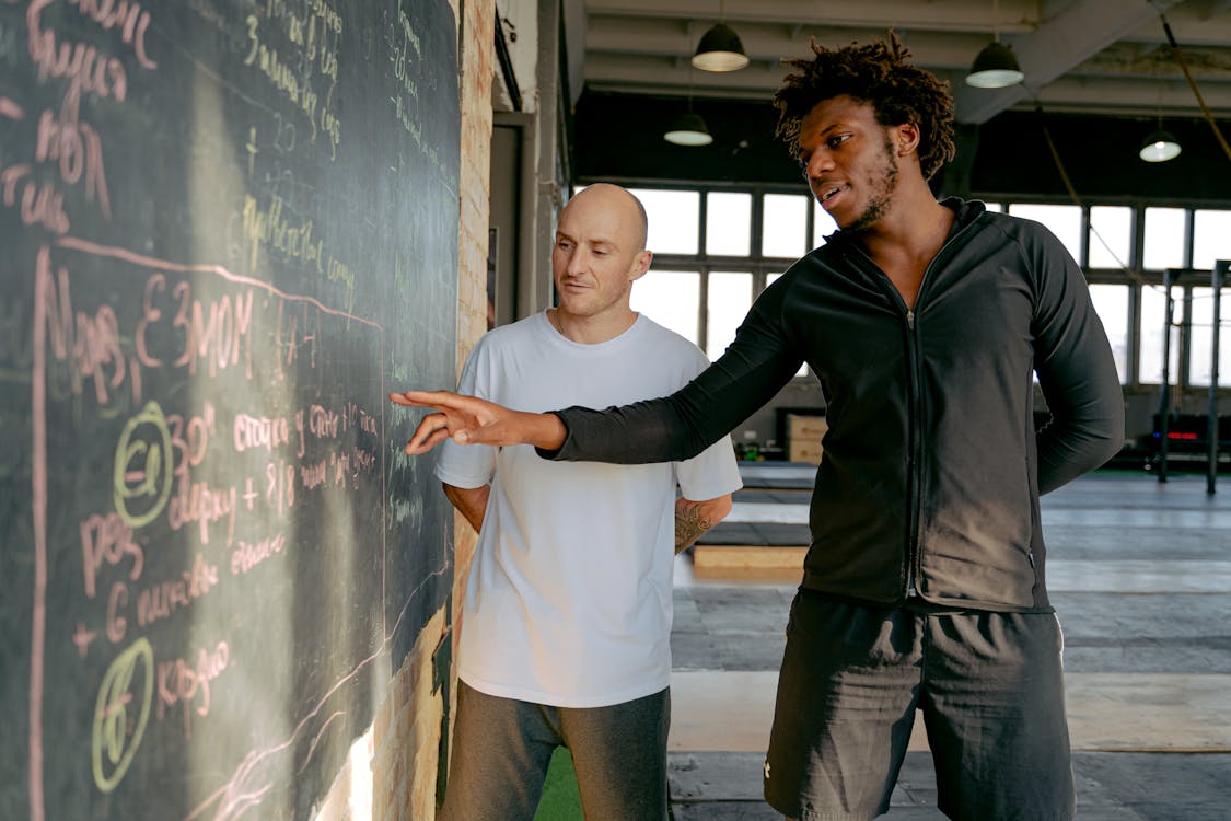 Free Personal Trainer Explaining an Exercise Plan to a Man  Stock Photo