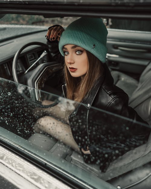 Calm female sitting in car and looking at camera