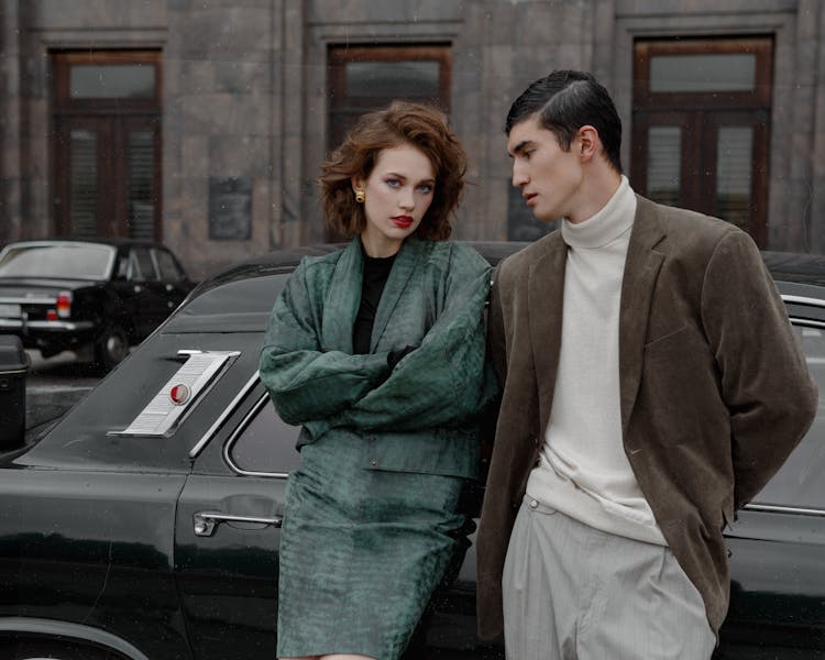 Stylish Young Couple Leaning On Car