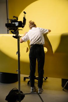Capturing a behind-the-scenes look at a creative studio setup with a yellow backdrop and camera equipment.