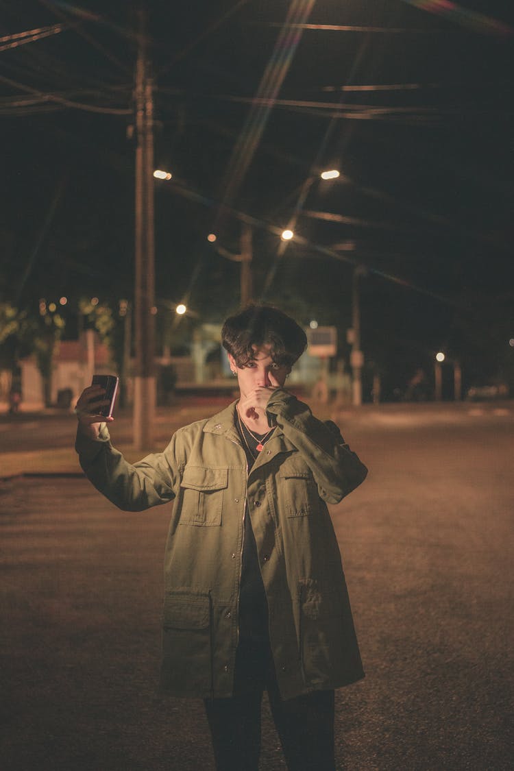 Boy In Jacket Holding A Phone