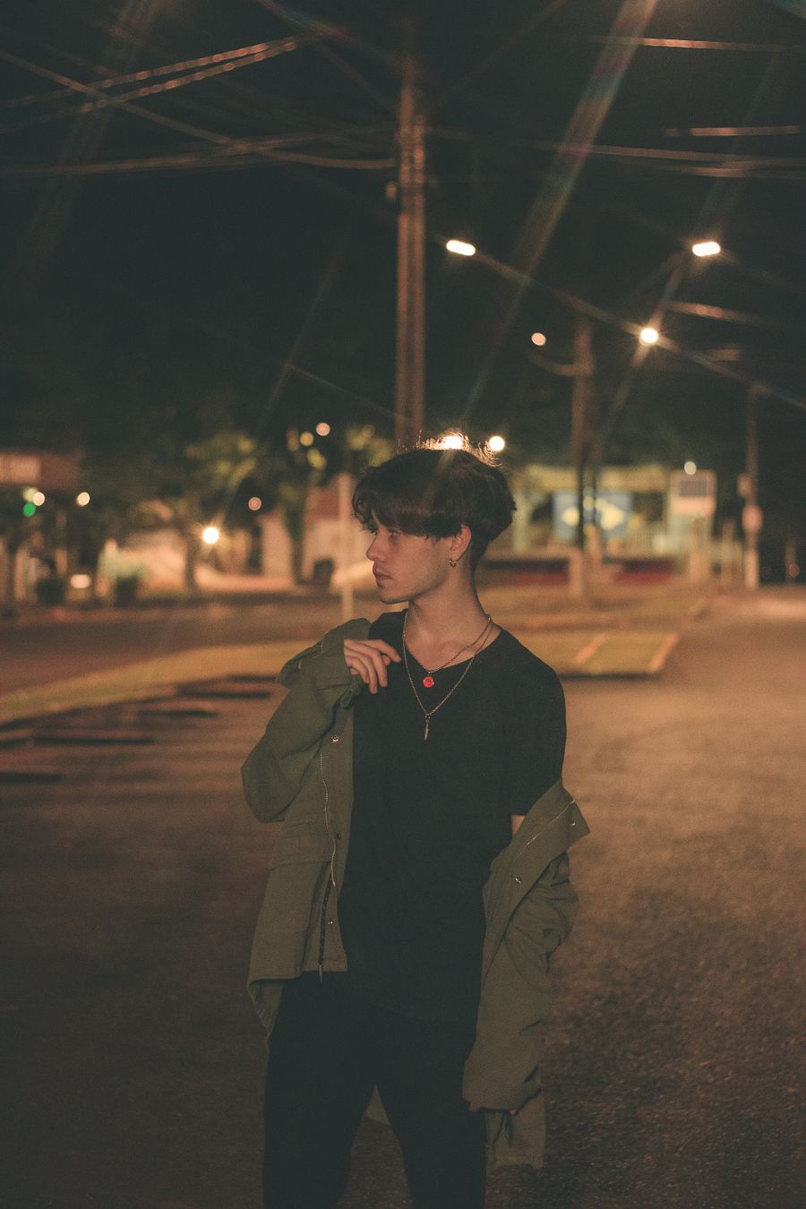 Model wearing a dark statement tee on a city street at night