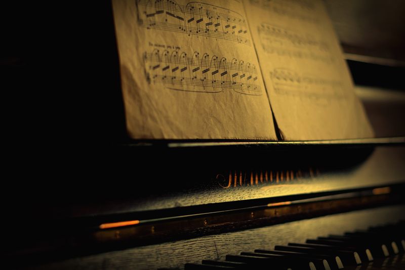 Teclas de piano antiguas junto a una partitura