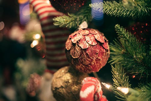 Decorative cone on fir tree with glowing garland