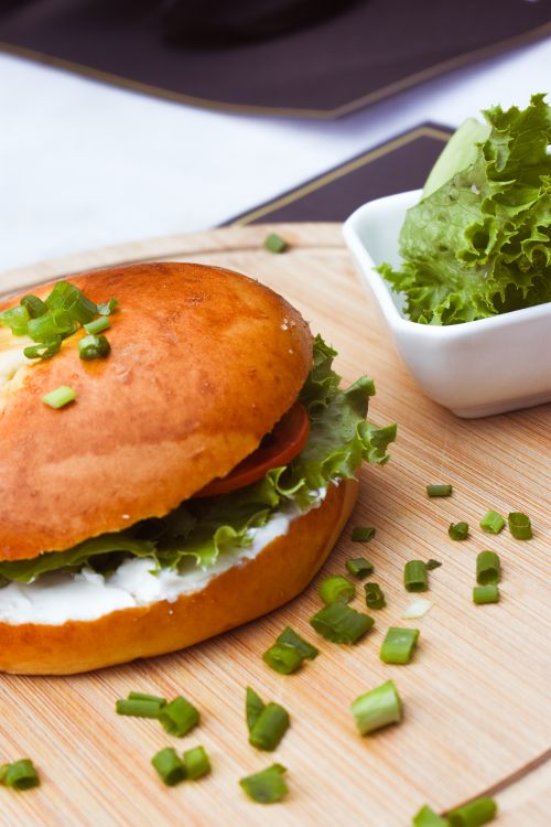 Free Appetizing veggie burger on wooden tray with fresh lettuce and green onions. Stock Photo