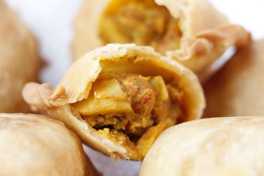 Delicious close-up of crispy Asian pastry with savory filling, perfect for food lovers.