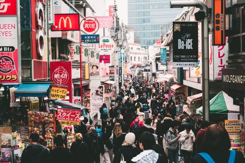 Free Vibrant daytime street market in Tokyo, crowded with shoppers and colorful signage. Stock Photo
