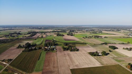 Free Expansive aerial view of farmland in Nadrybie Ukazowe, showcasing lush fields and rural landscape under a clear sky. Stock Photo
