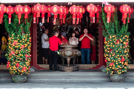 在新加坡的一座中国寺庙里，人们装饰着灯笼和饰品，为庆祝吉祥的活动而祈祷