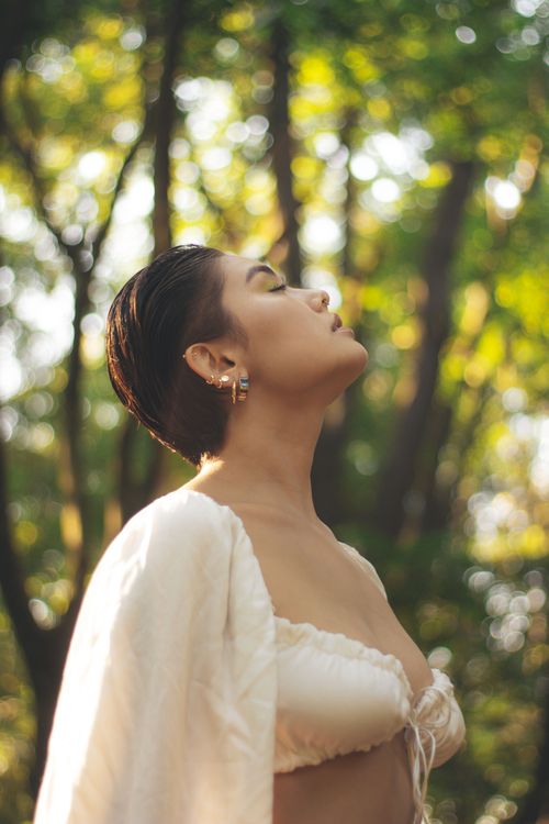 Free Woman enjoying the sunlight in a tranquil forest setting, São Paulo. Stock Photo