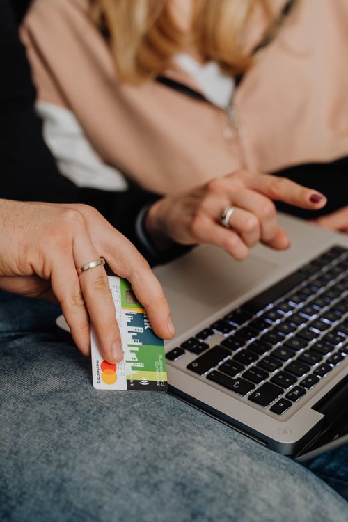 Free Close-up of a couple's hands using a laptop for online shopping with a credit card. Stock Photo