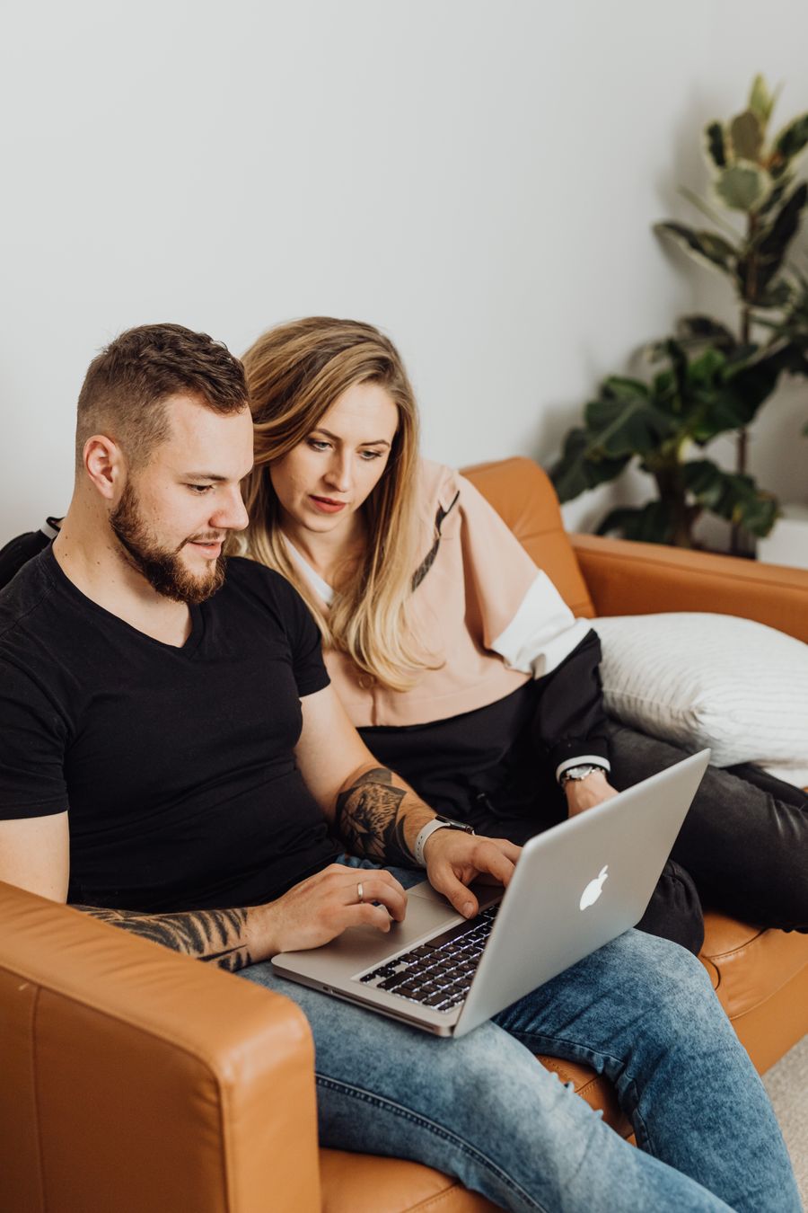 A couple on their couch comparing local contractors on a laptop