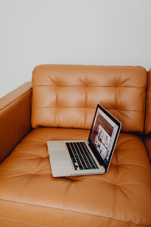 Free Laptop on the Brown Leather Couch Stock Photo