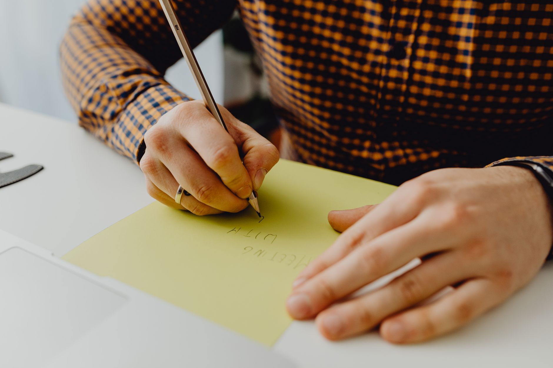 A person writing notes by hand on paper during focused work.