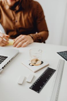 A tidy office desk setup with laptop, glass cup, and stationery, depicting a productive work atmosphere.