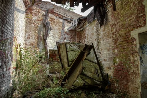 Free Explore an abandoned brick ruin with broken windows and overgrown plants in Leipzig, Germany. Stock Photo