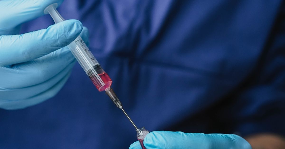 Enjecting A Person Injecting a Loaded Syringe · Free Stock Photo