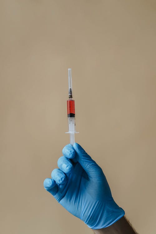 A Hand Holding a Syringe 