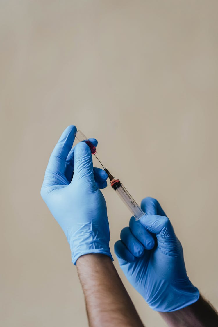 A Person Loading A Syringe