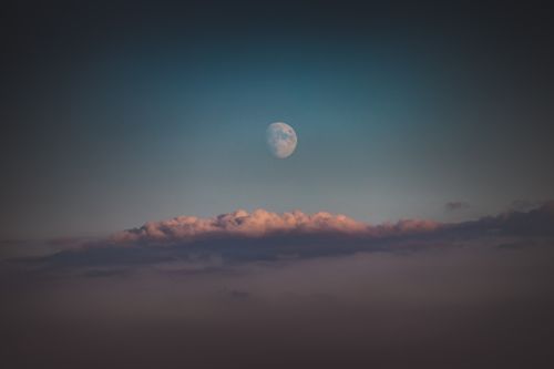 Free A tranquil view of the half moon rising above colorful clouds in Podkarpackie, Poland's sky. Stock Photo