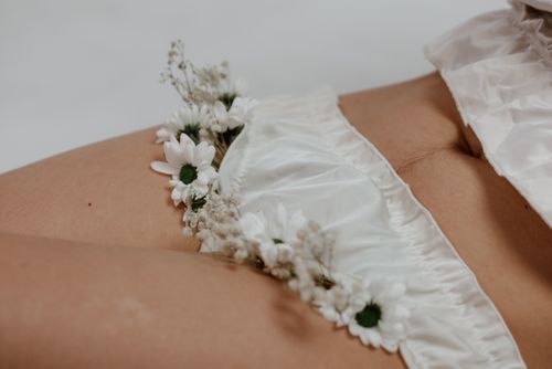 Free Close-up of a white floral-decorated undergarment on skin, conveying elegance. Stock Photo