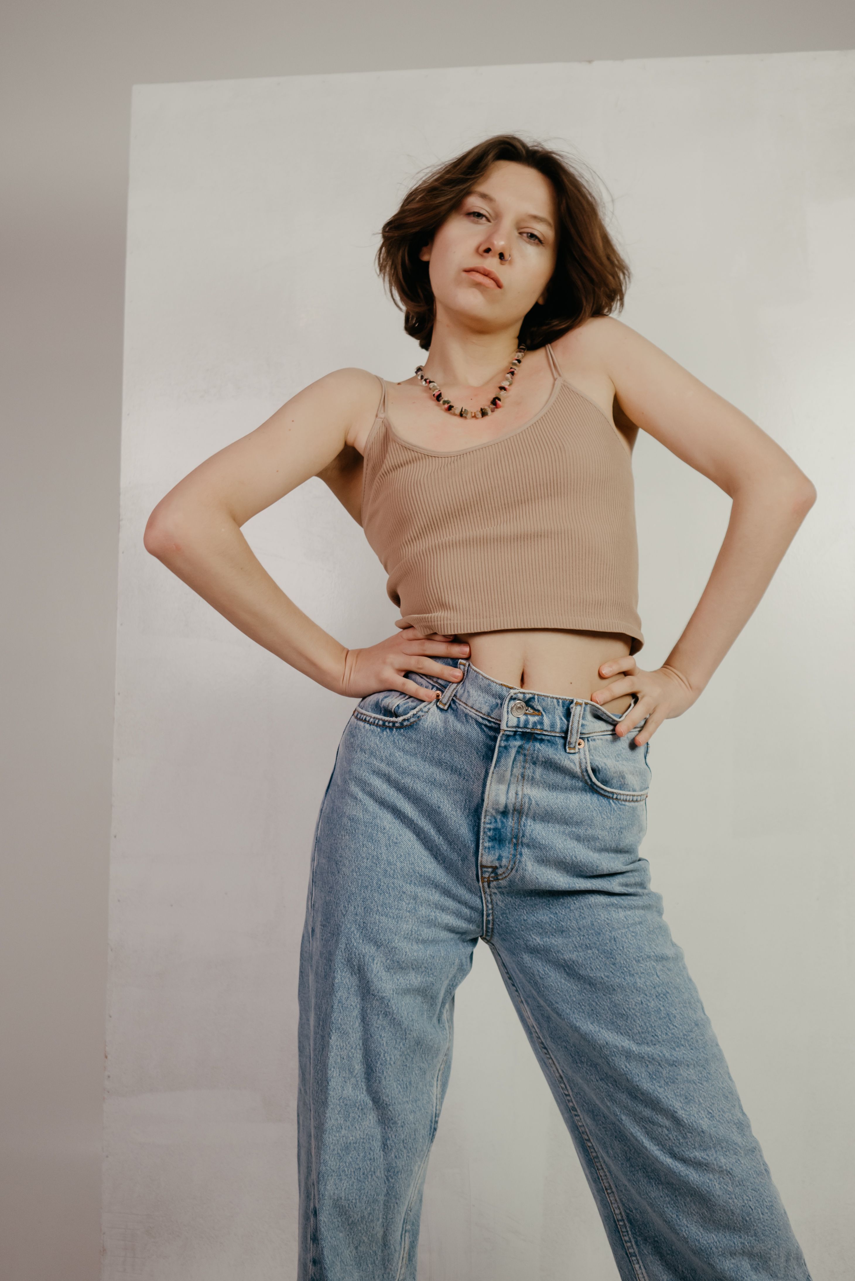 A Woman in Brown Tank Top and Denim Jeans Posing · Free Stock Photo