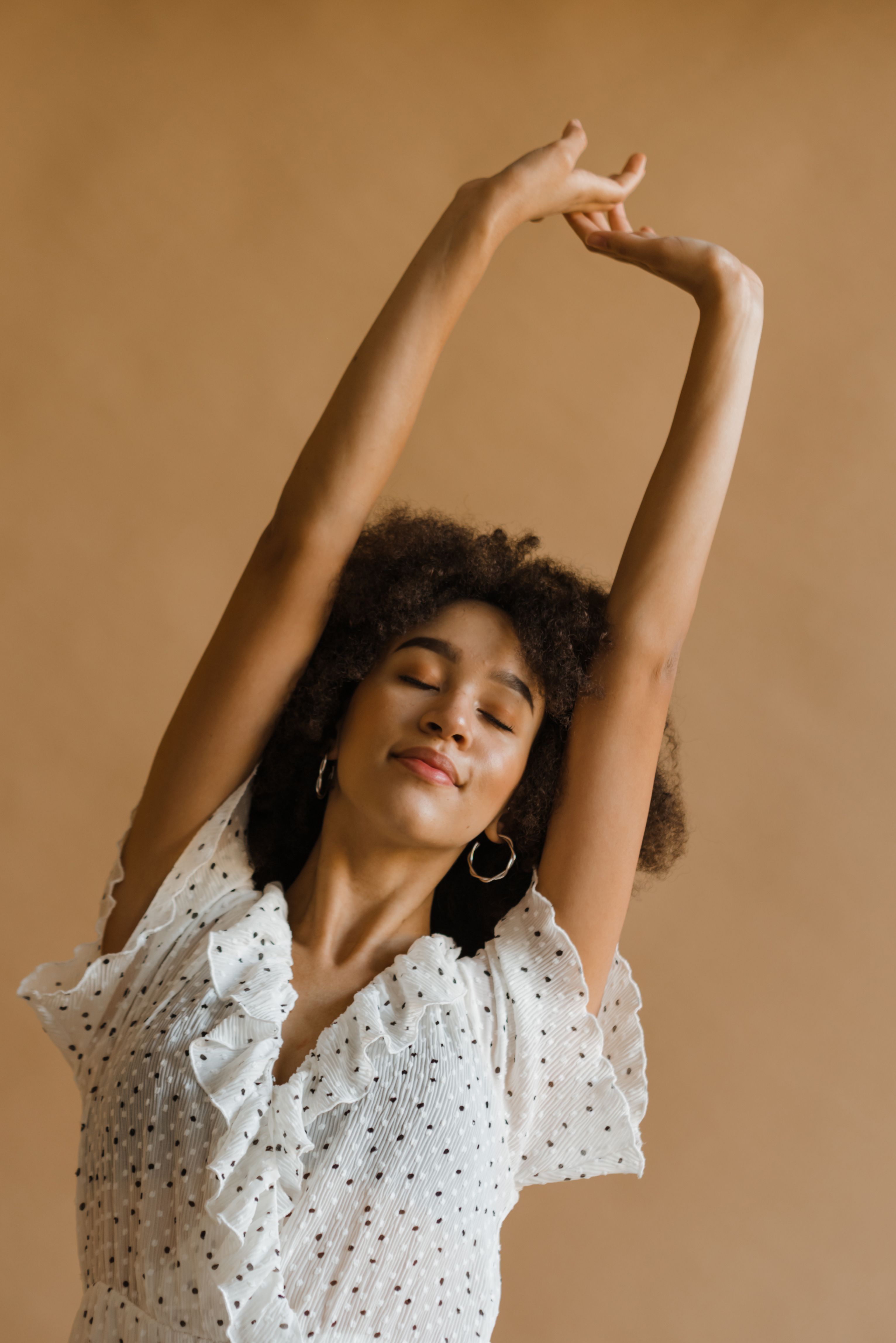 Woman in Polka Dot Dress Raising Her Hands · Free Stock Photo