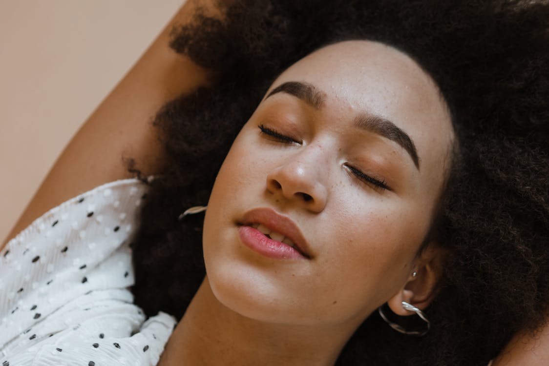 Free Peaceful young black woman relaxing with closed eyes Stock Photo