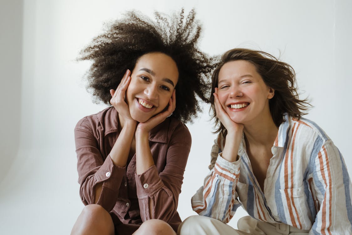 Free Women Smiling at the Camera while Sitting Stock Photo