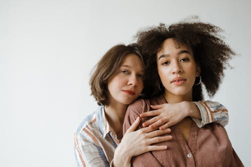 Free Women Hugging while Looking at the Camera Stock Photo