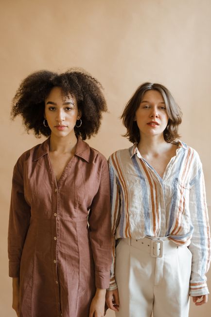 Portrait of two diverse women standing side by side in a studio shoot.