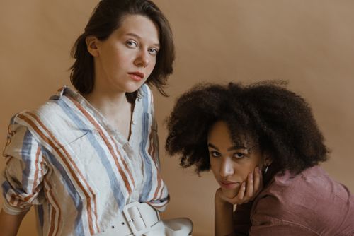 Free Two women posing fashionably indoors, showcasing diversity and style. Stock Photo