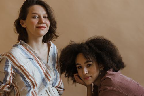 Free Two women expressing natural beauty and confidence in a studio setting with a neutral background. Stock Photo