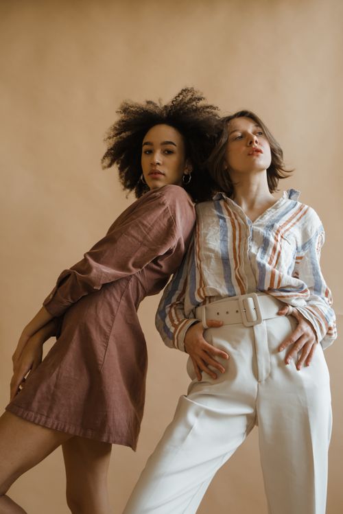 Free Elegant portrait of two women in fashionable attire against a neutral backdrop. Stock Photo