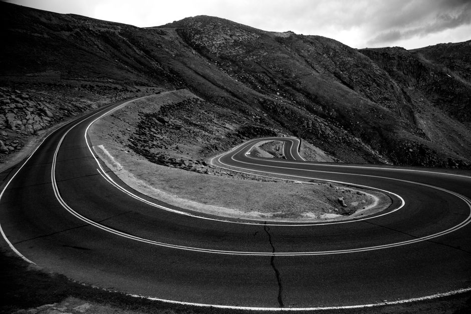 Stunning monochrome view of winding mountain roads in Colorado's rugged terrain.