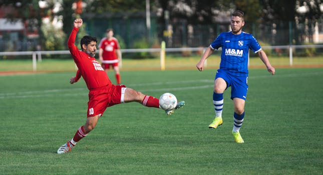 Players in vibrant uniforms compete in a dynamic soccer match outdoors.