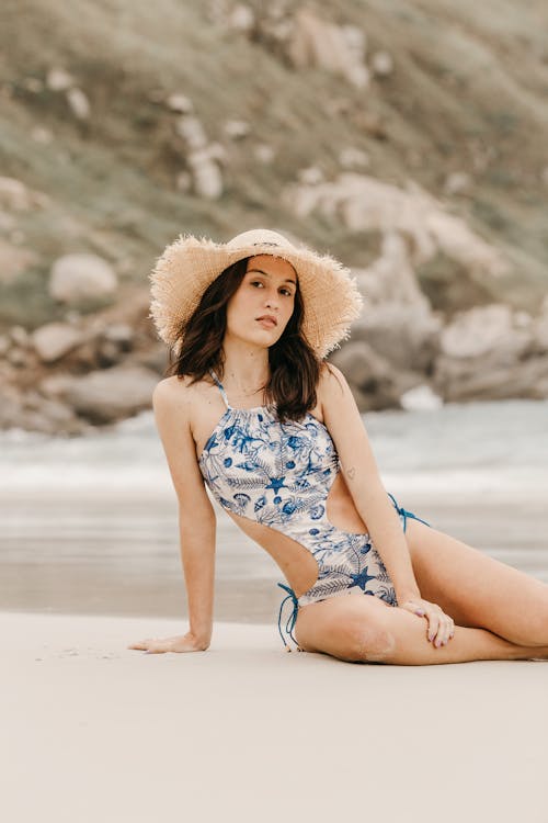Feminine model in swimsuit on sea shore in summer
