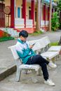 Boy in Blue Jacket Sitting on Brown Wooden Bench