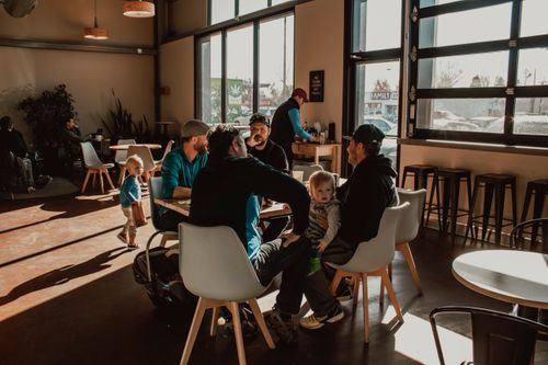 Free A group of friends enjoying a sunny afternoon in a modern café. Stock Photo