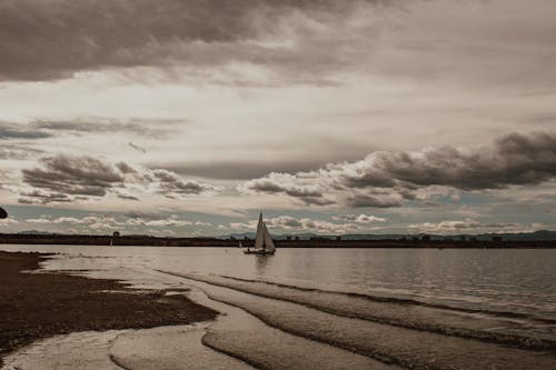 Free A Sailboat under a Cloudy Sky Stock Photo