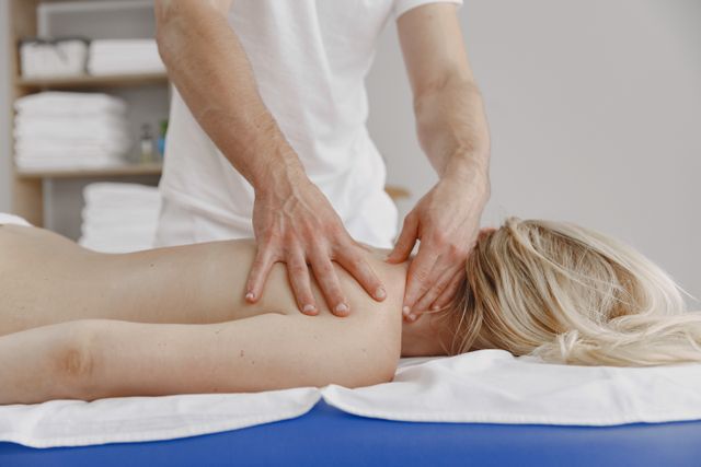 Femme allongée recevant un massage du dos dans une ambiance calme de spa