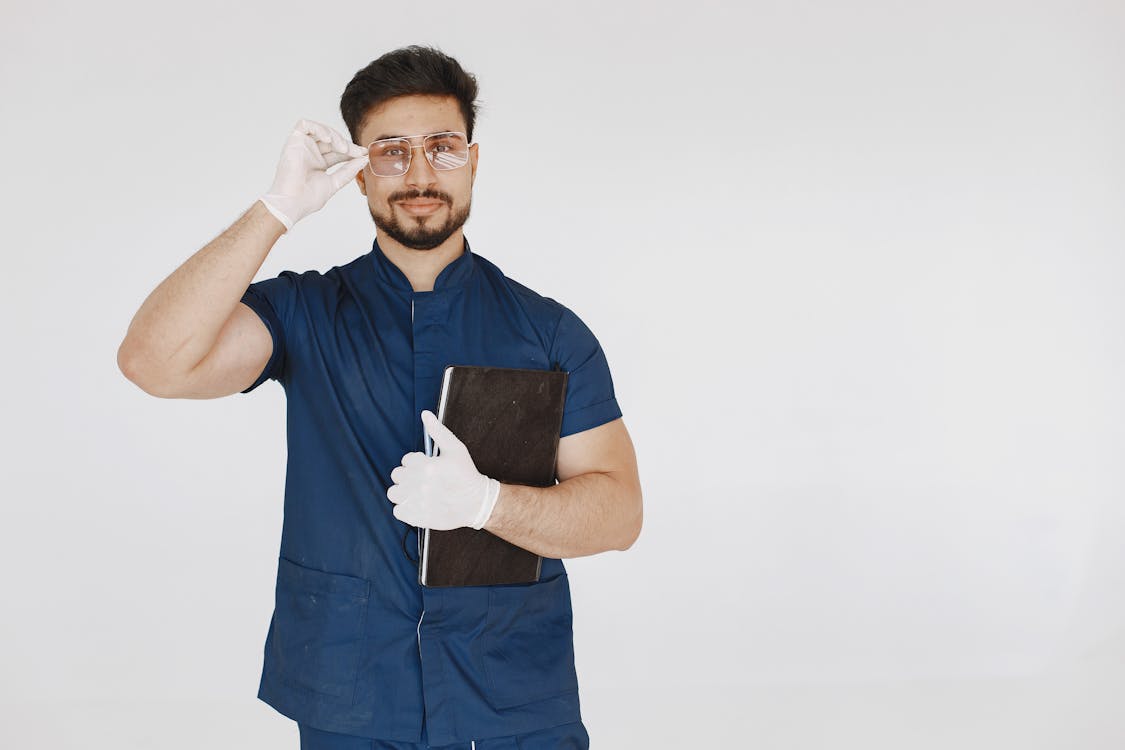 A Man in a Scrub Suit Holding a Book