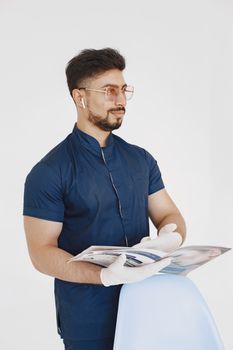 A confident medical professional in uniform holding a brochure indoors.