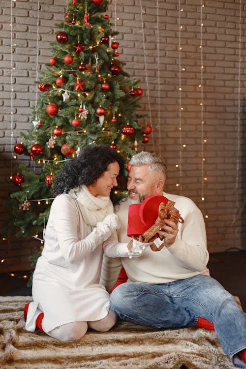 Elderly Couple Smiling Under the Christmas Tree