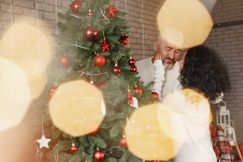 Man and Woman Kissing Beside Christmas Tree