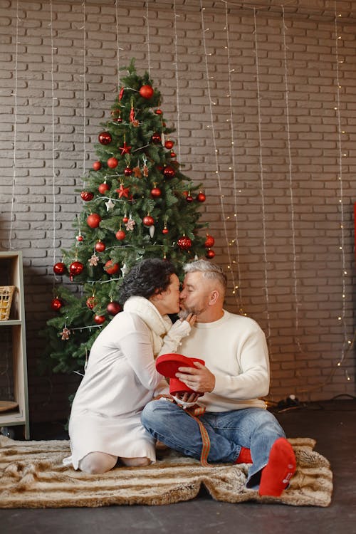 Elderly Couple Kissing Beside the Christmas Tree