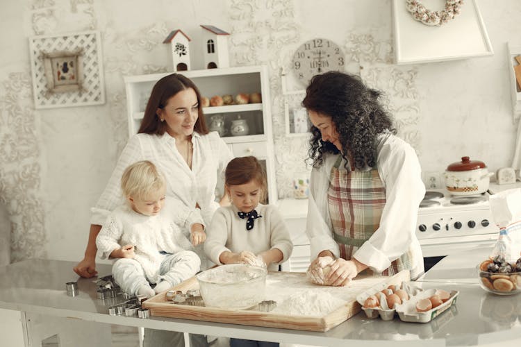 Three Generations, Mother, Daughters And Grandmother Baking Together 