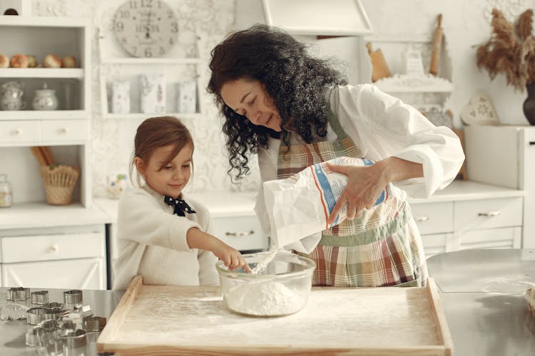 Mother And Daughter Making Cake Together