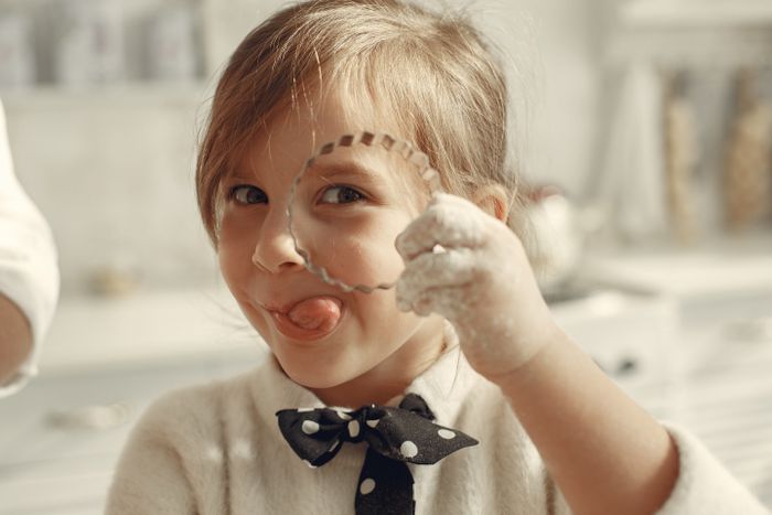 Little baker playfully holding a cookie cutter